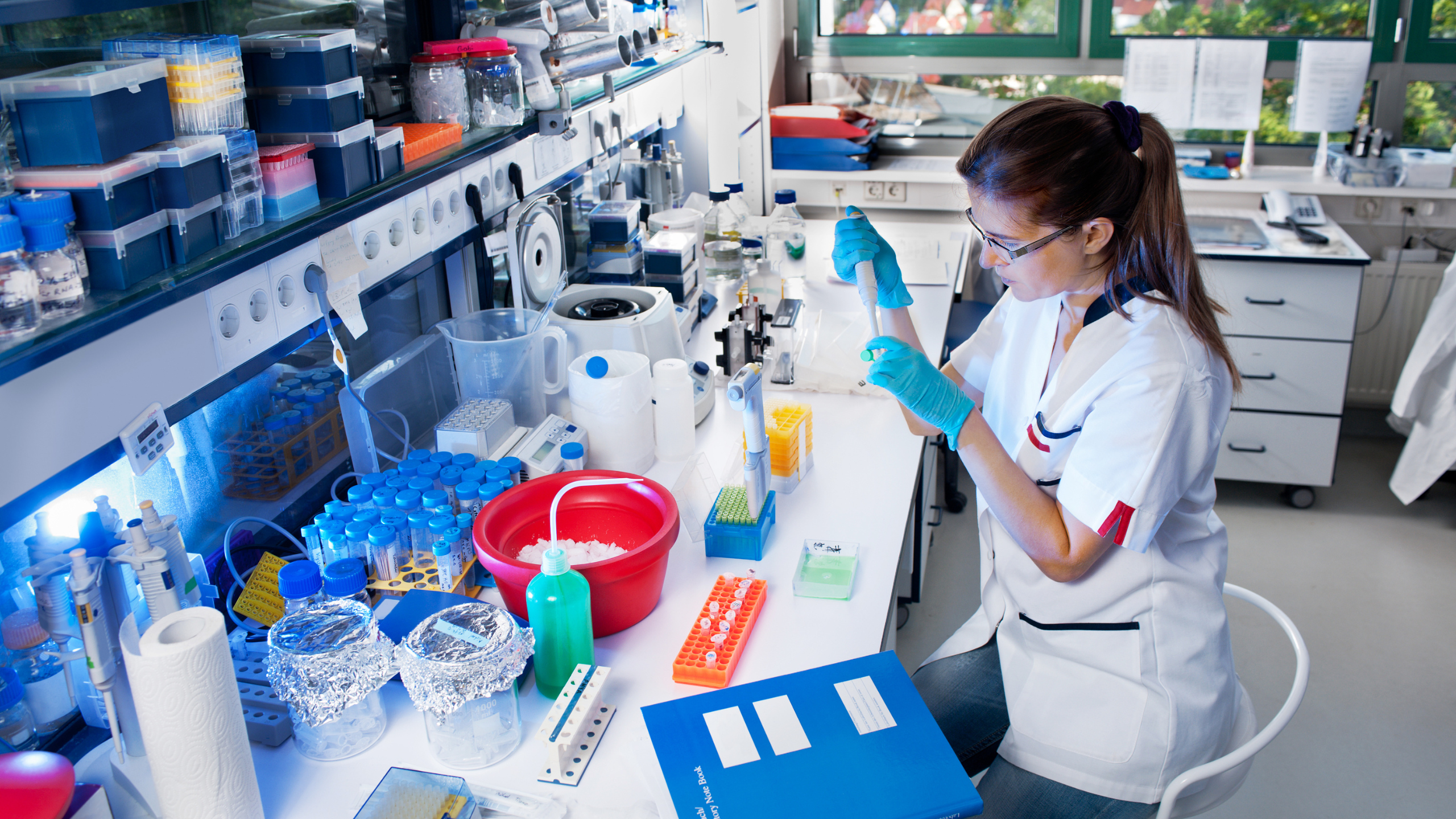 A pharmaceutical scientist works with digital lab equipment in a high-tech research environment. The image reflects the evolving role of digital tools in drug discovery and development, and aligns with Axion’s focus on placing talent at the intersection of science, data and compliance in modern pharma.